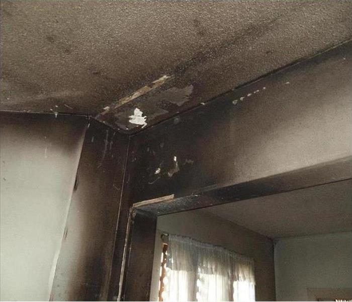 Wall has suffered severe smoke damage due to a kitchen fire.